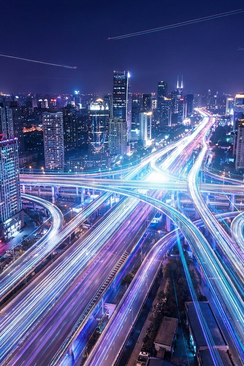 Digitale Vernetzung - Moderne Stadt bei Nacht mit Lichtspuren